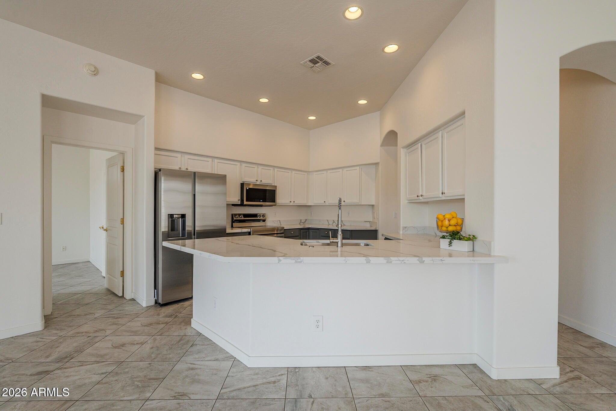 3910 East Carson Road Phoenix, AZ 85042 - Photo 6 of 19 a large kitchen with stainless steel appliances granite countertop a stove a refrigerator a sink and a refrigerator