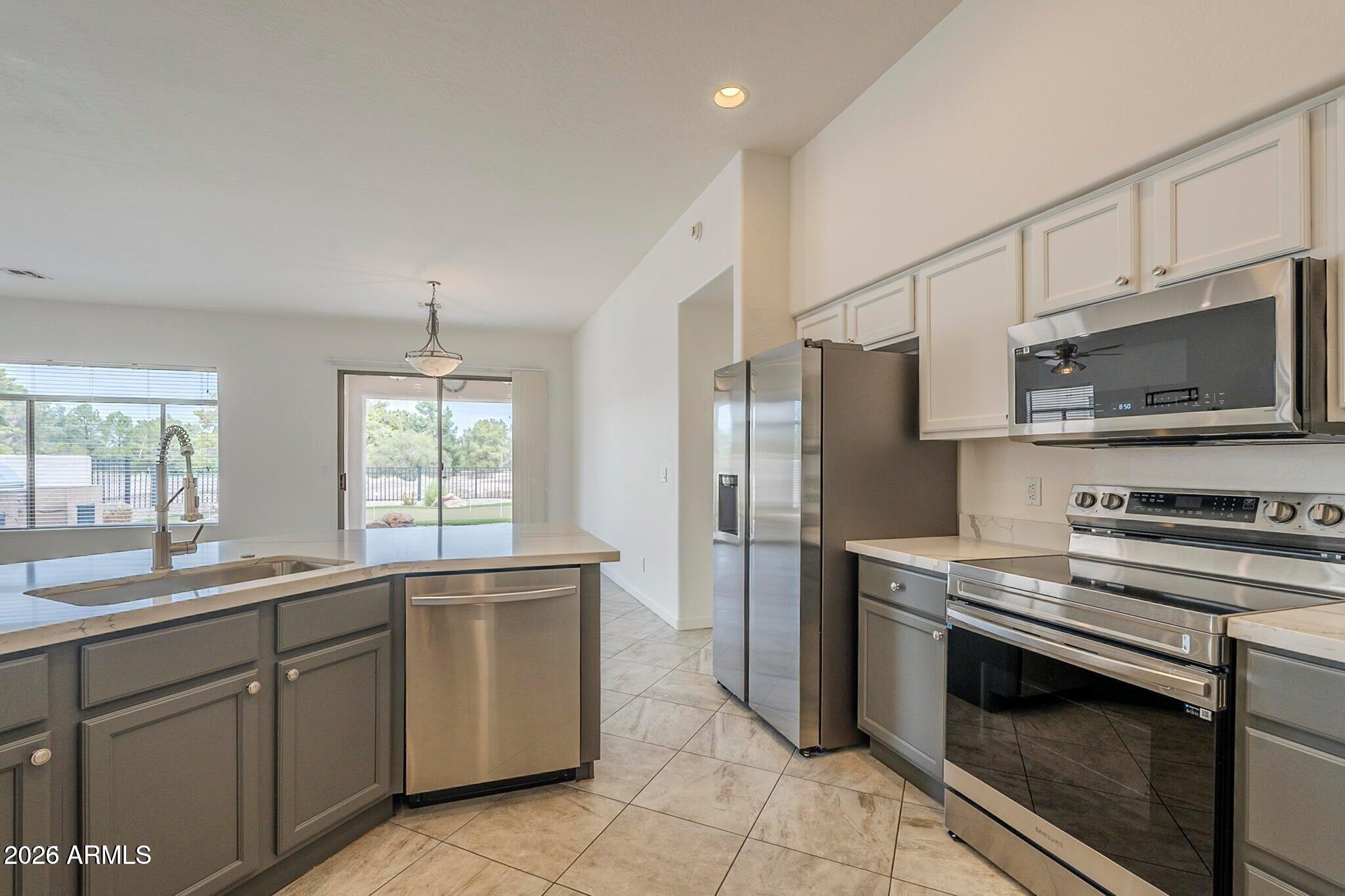 3910 East Carson Road Phoenix, AZ 85042 - Photo 8 of 19 a kitchen with stainless steel appliances a sink cabinets and a window