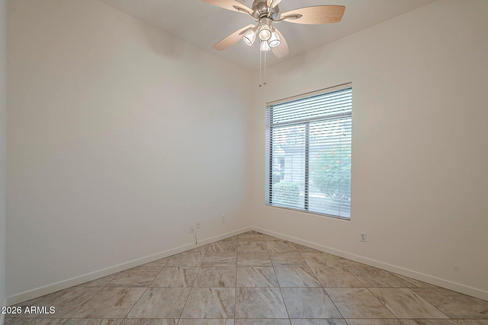 3910 East Carson Road Phoenix, AZ 85042 - Photo 9 of 19 an empty room with a window and a fan