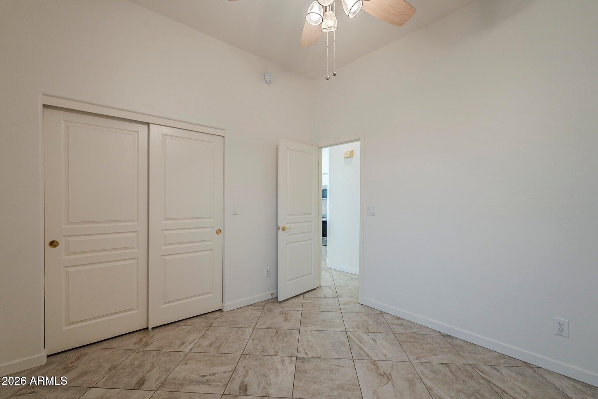 3910 East Carson Road Phoenix, AZ 85042 - Photo 10 of 19 an empty room with chandelier fan