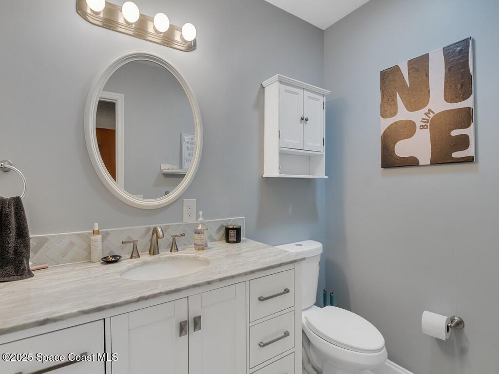 2020 Vero S Circle Southwest, Unit 4 Vero Beach, FL 32962 - Photo 12 of 33 a bathroom with a granite countertop toilet sink and mirror