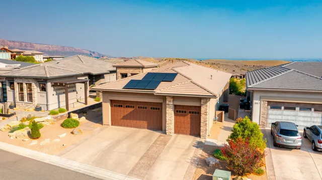 a view of a house with a barbeque and large trees