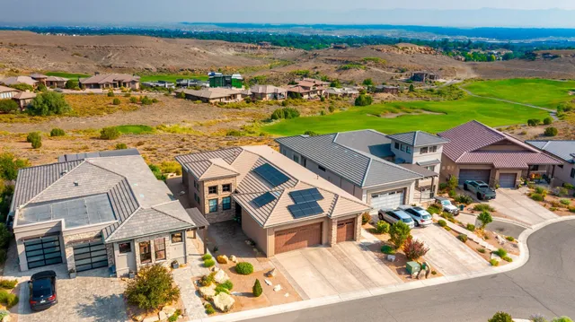 an aerial view of residential houses with outdoor space and ocean view