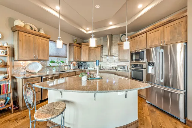 a kitchen with stainless steel appliances granite countertop a sink refrigerator and cabinets