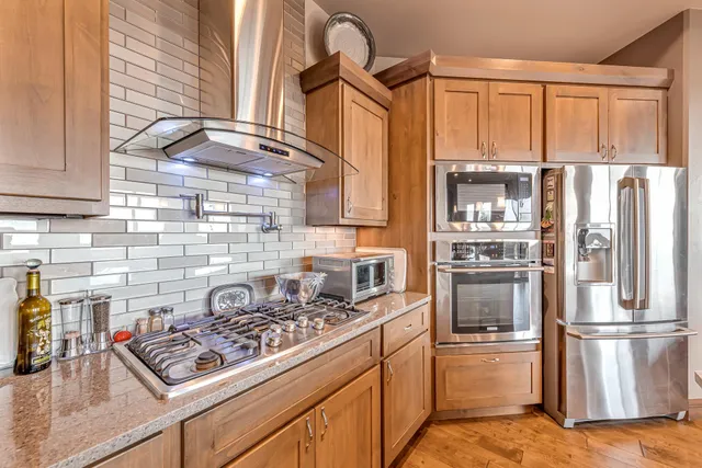a kitchen with stainless steel appliances granite countertop a refrigerator and a stove