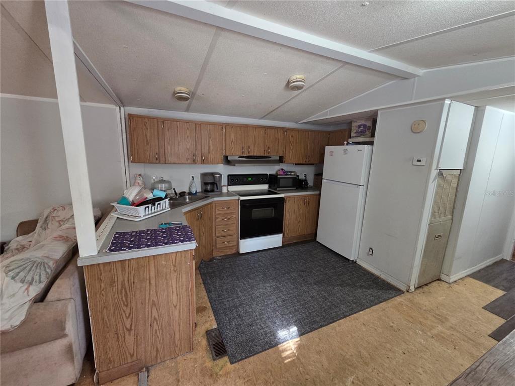 114 Lemon Street Melrose, FL 32666 - Photo 4 of 17 a kitchen with granite countertop a refrigerator and a stove top oven