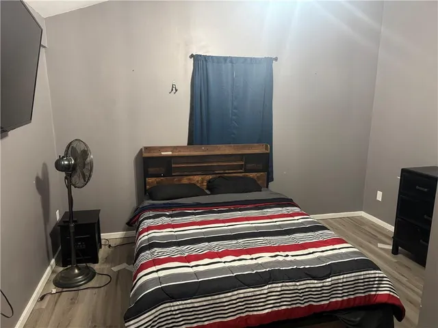 a bedroom with a bed and a flat screen tv