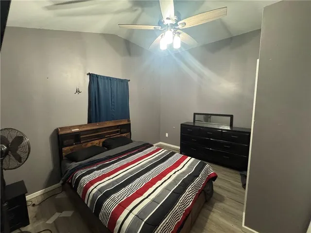 a bedroom with a bed and a ceiling fan