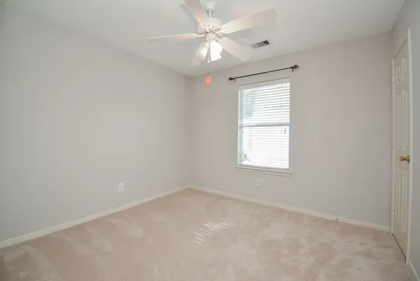 an empty room with a window and a fan