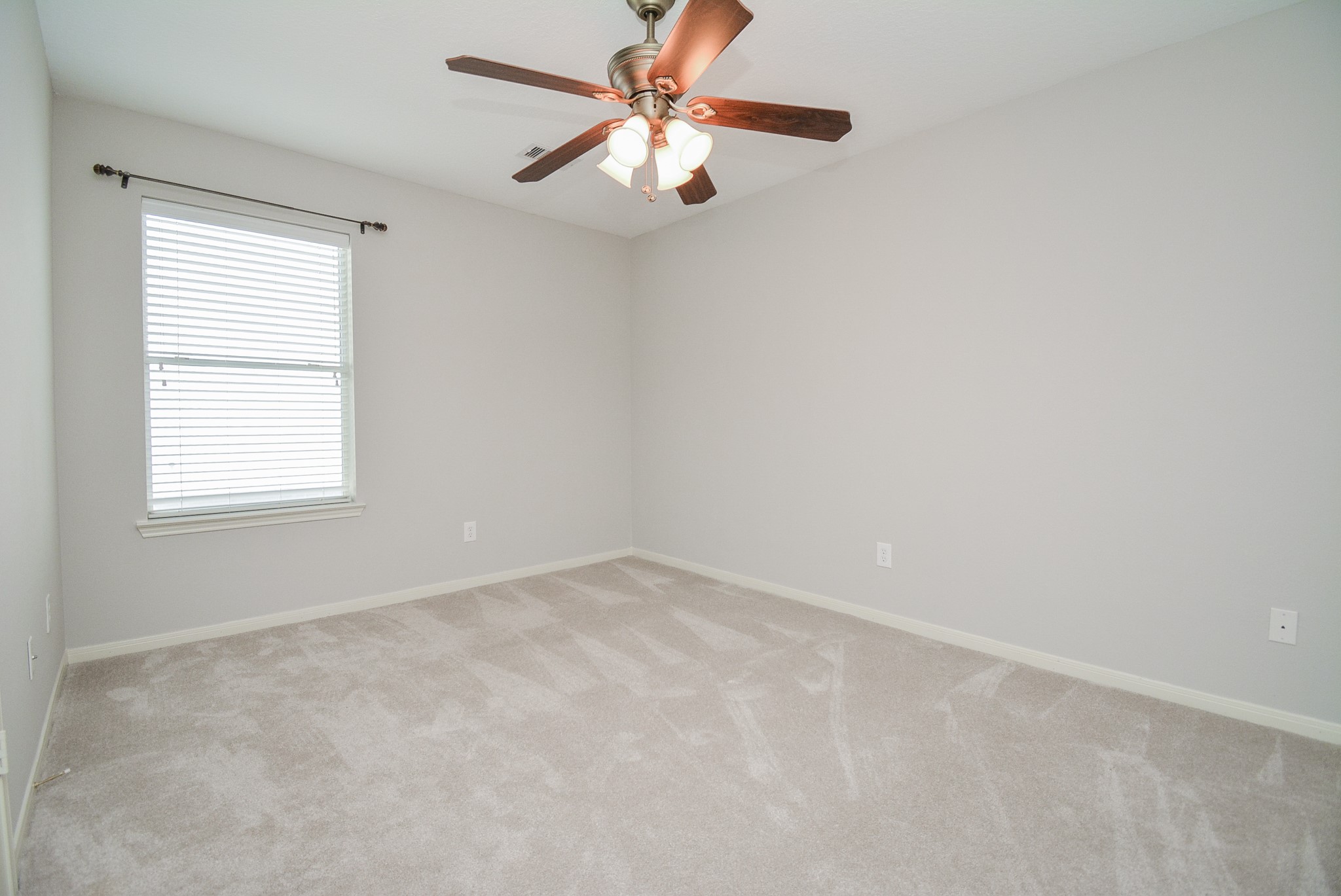 18714 Flagstone Creek Road Houston, TX 77084 - Photo 13 of 50 an empty room with a window and a fan