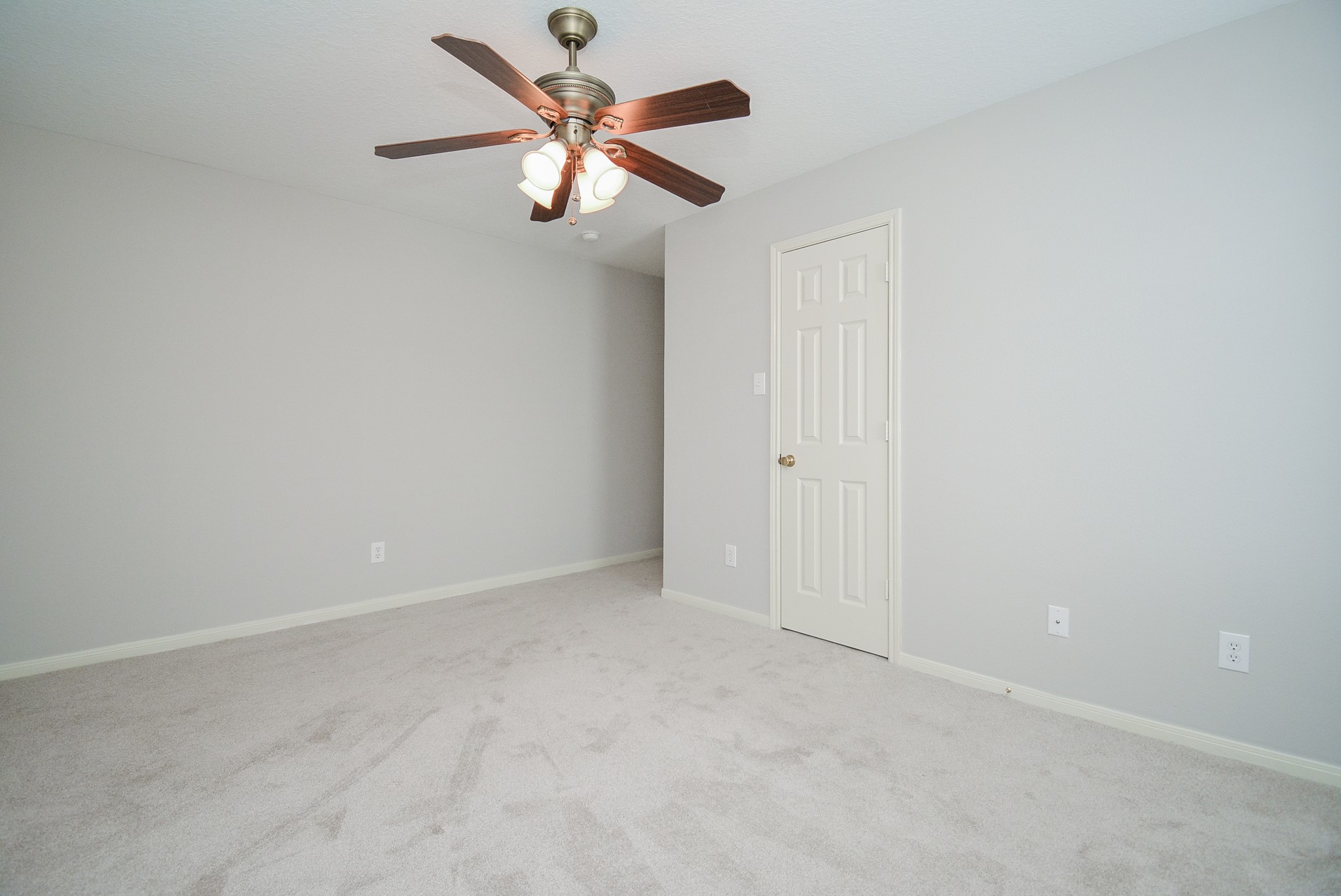 18714 Flagstone Creek Road Houston, TX 77084 - Photo 14 of 50 an empty room with a chandelier fan and windows