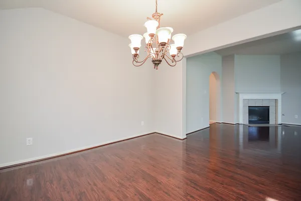 a view of a room with wooden floor and chandelier