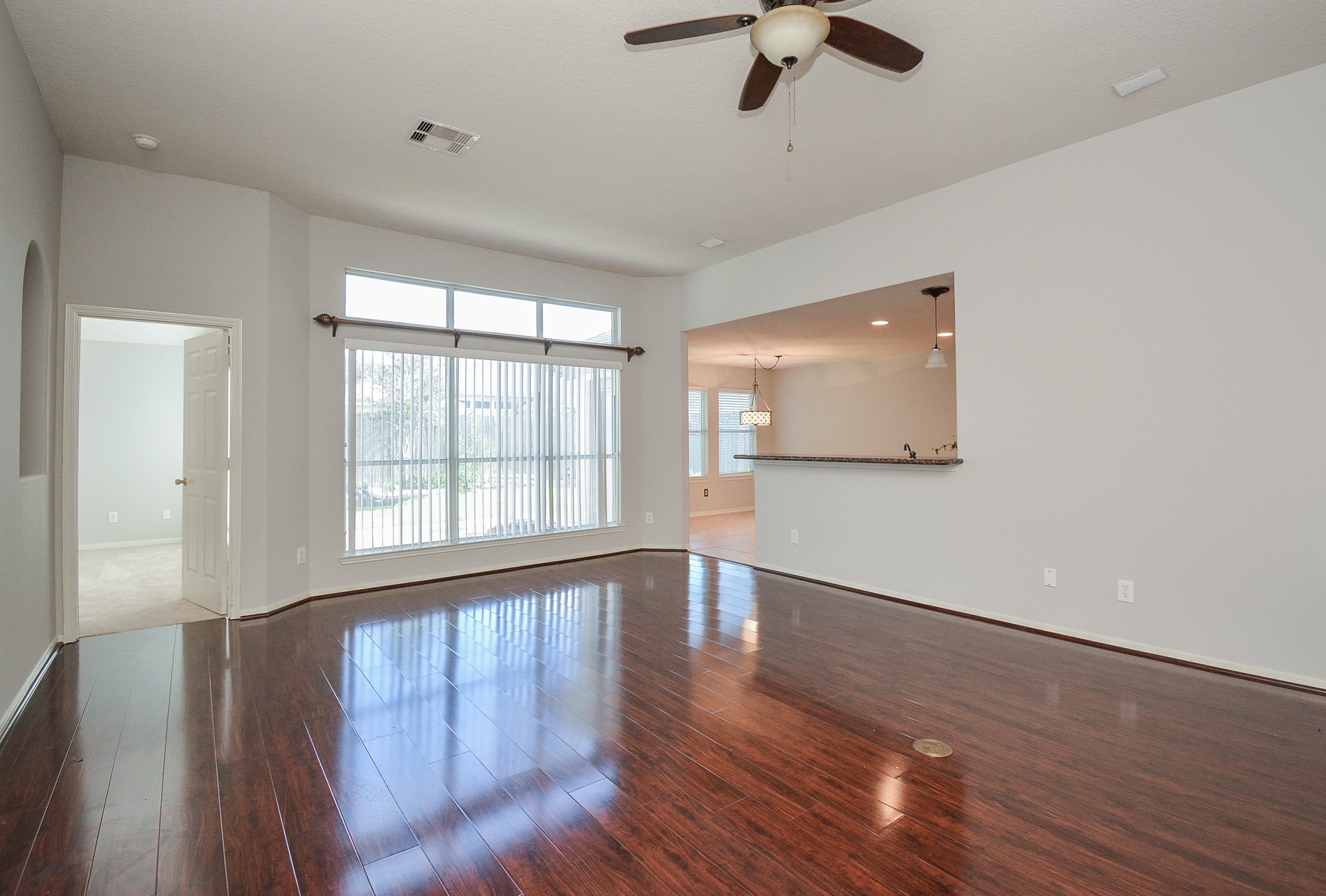 18714 Flagstone Creek Road Houston, TX 77084 - Photo 21 of 50 an empty room with wooden floor fan and windows