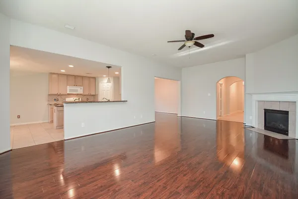 a view of empty room with wooden floor and fireplace