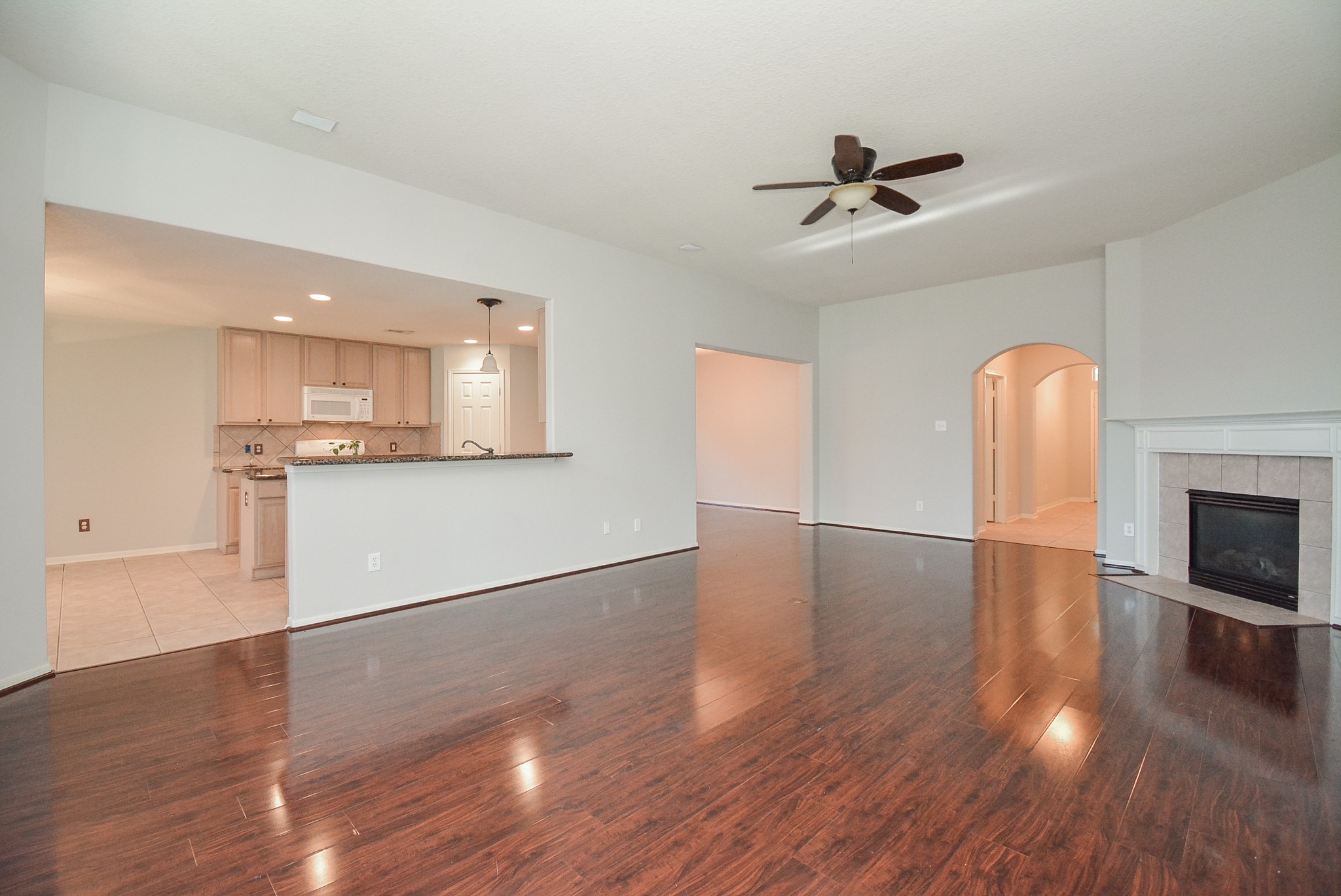 18714 Flagstone Creek Road Houston, TX 77084 - Photo 22 of 50 a view of a kitchen with a sink a fireplace a ceiling fan and wooden floor