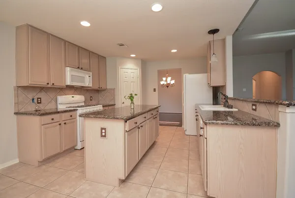 a kitchen with stainless steel appliances granite countertop a sink and a stove