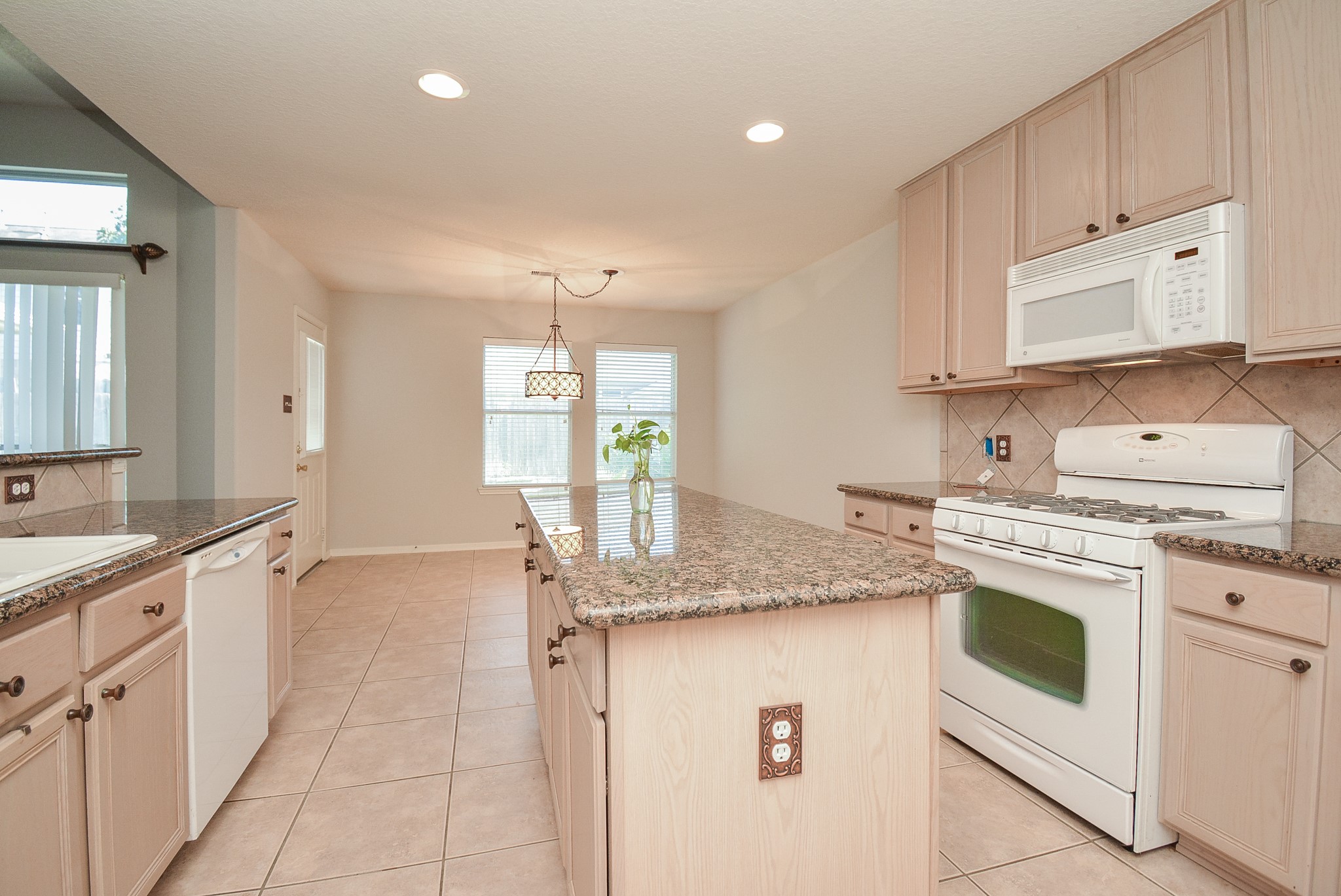 18714 Flagstone Creek Road Houston, TX 77084 - Photo 33 of 50 a kitchen with granite countertop a sink stove and cabinets