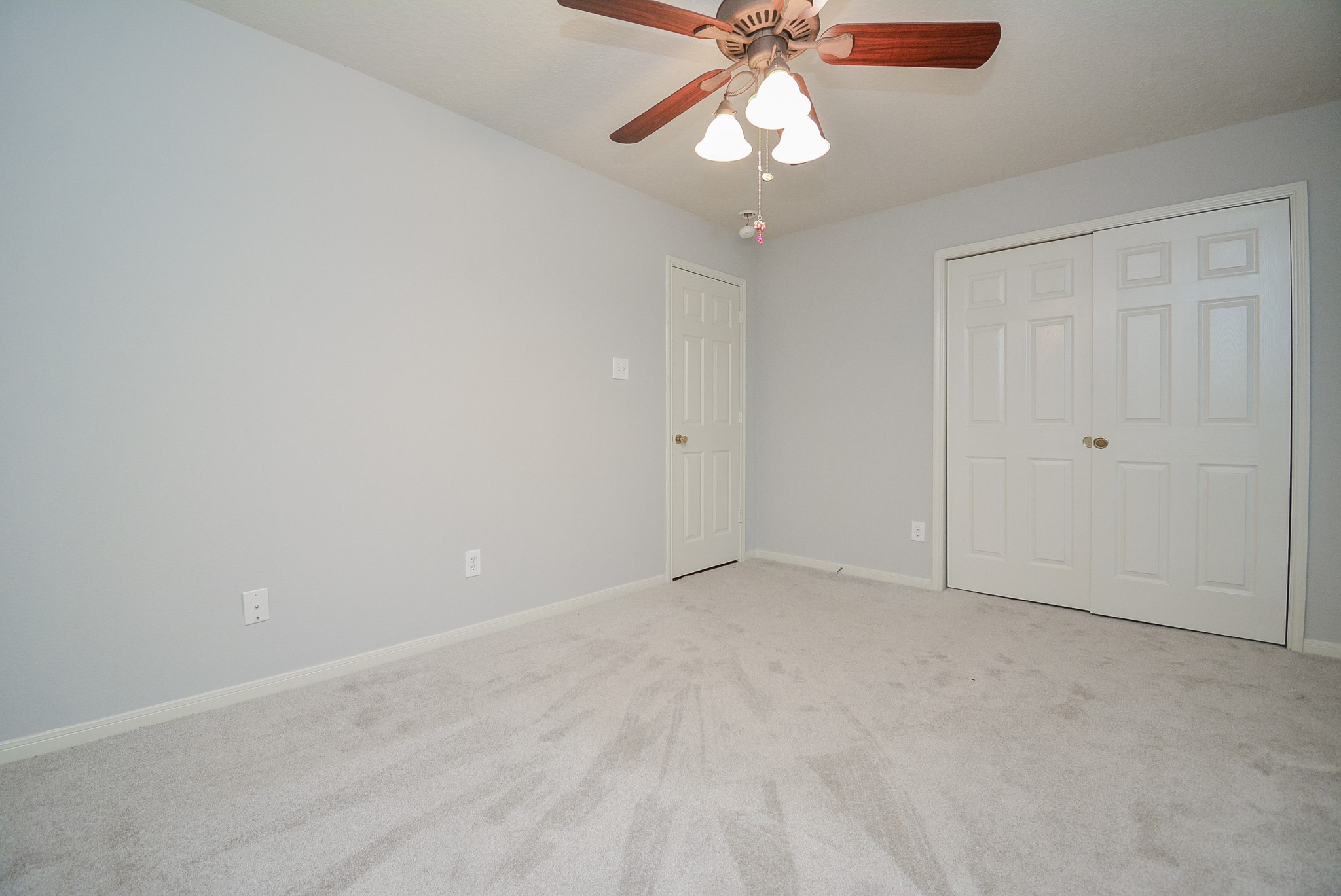 18714 Flagstone Creek Road Houston, TX 77084 - Photo 8 of 50 an empty room with a chandelier fan and glass door