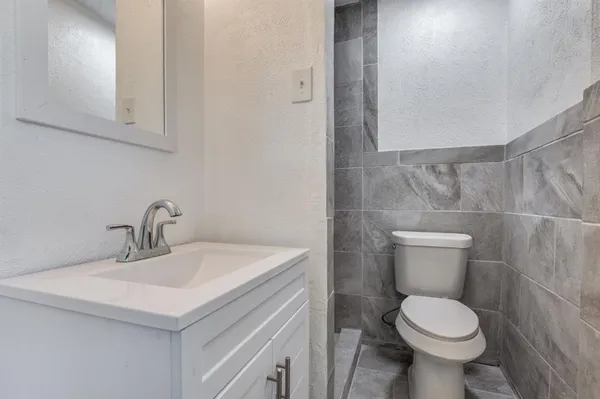 a bathroom with a sink toilet and a mirror