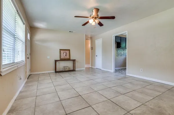 an empty room with windows and ceiling fan