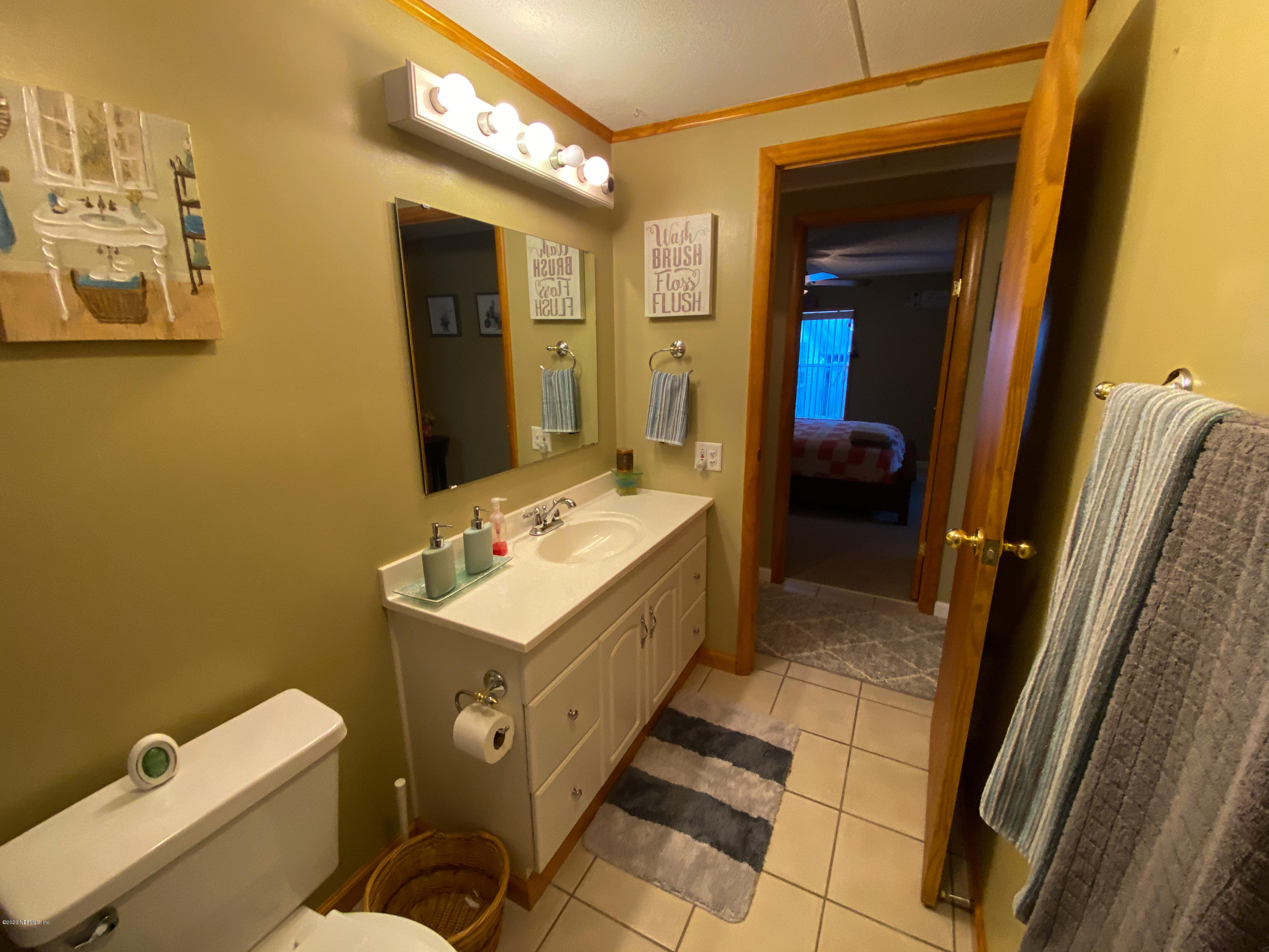 86116 Pages Dairy Road Yulee, FL 32097 - Photo 19 of 46 a bathroom with a sink a toilet and mirror