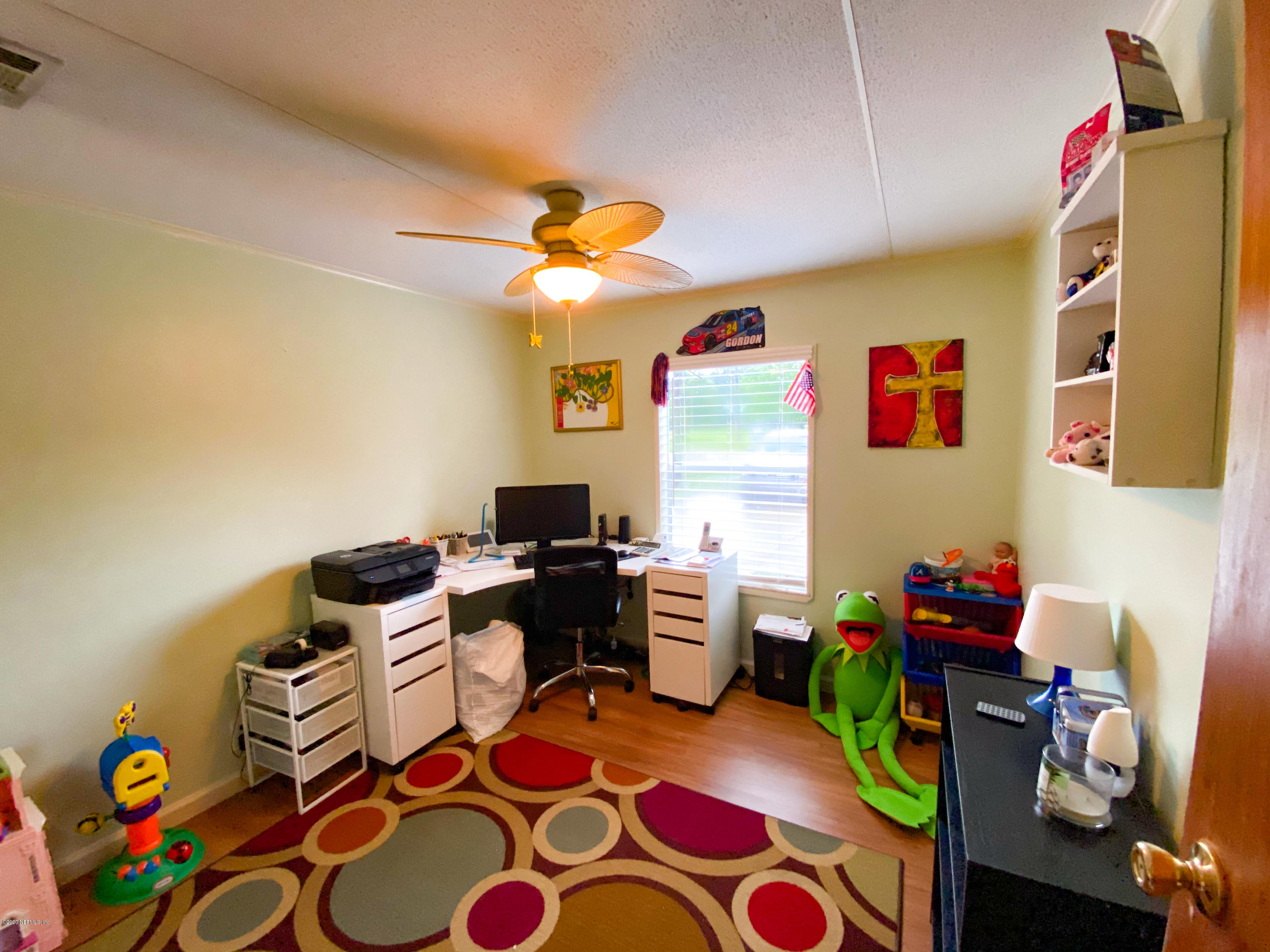 86116 Pages Dairy Road Yulee, FL 32097 - Photo 21 of 46 a view of a workspace with furniture and a flat screen tv