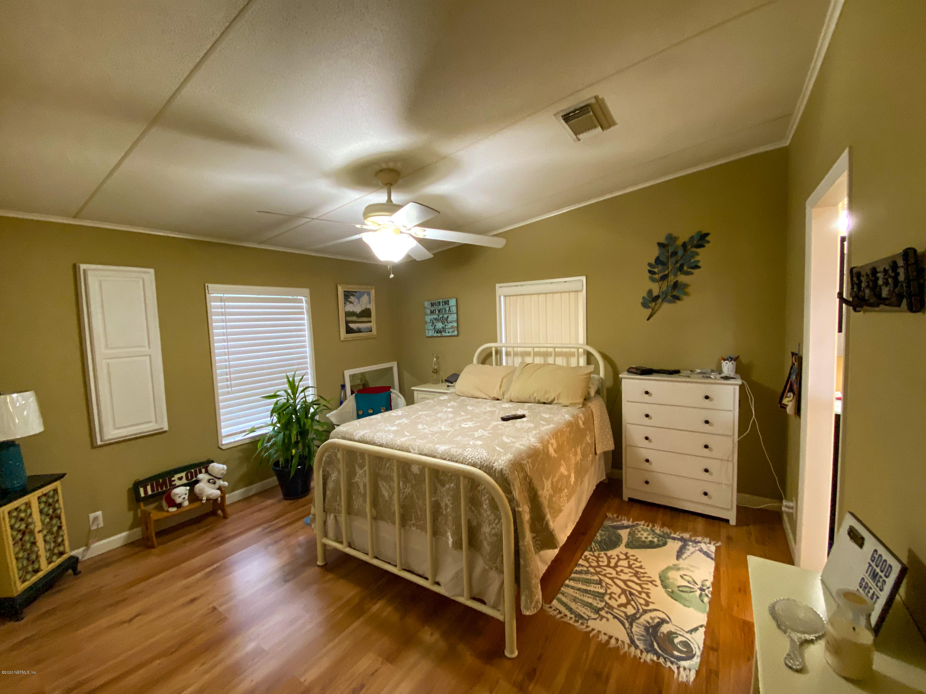 86116 Pages Dairy Road Yulee, FL 32097 - Photo 27 of 46 a spacious bedroom with a bed and a chandelier