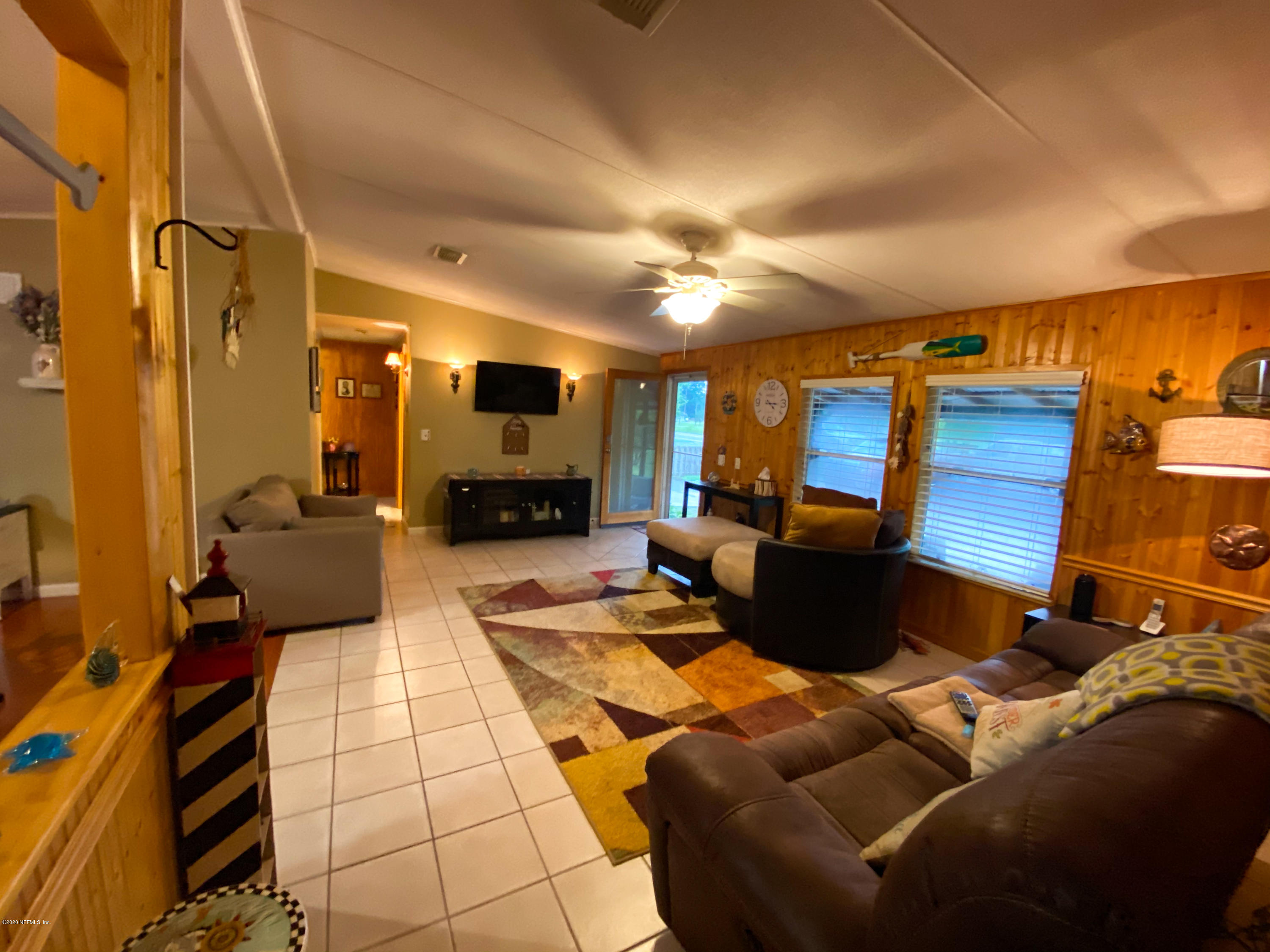 86116 Pages Dairy Road Yulee, FL 32097 - Photo 7 of 46 a living room with furniture a fireplace and a flat screen tv
