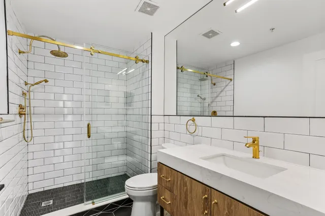 a bathroom with a sink a toilet and shower