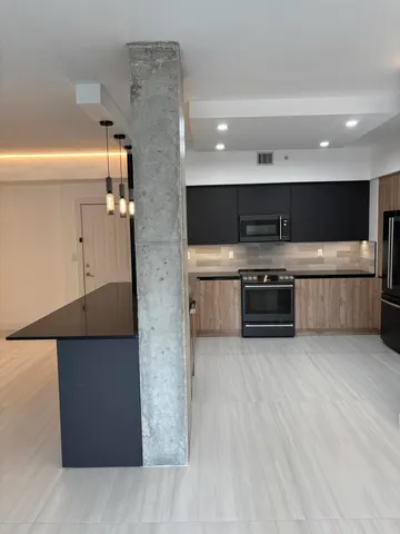 a large kitchen with stainless steel appliances granite countertop a large counter top and a stove