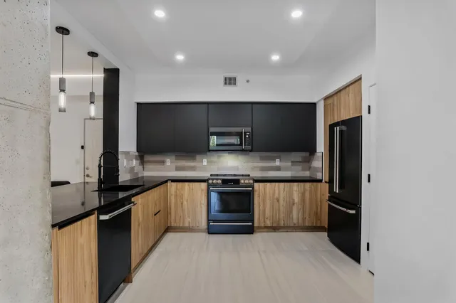 a large kitchen with stainless steel appliances a refrigerator and a stove top oven