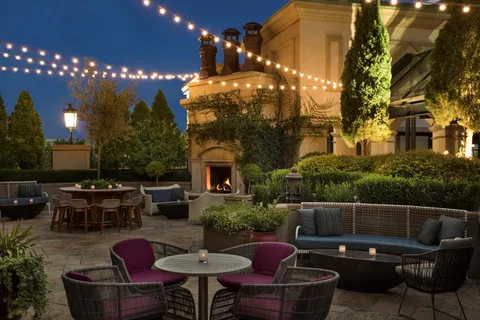 a view of a patio with couches table and chairs and potted plants