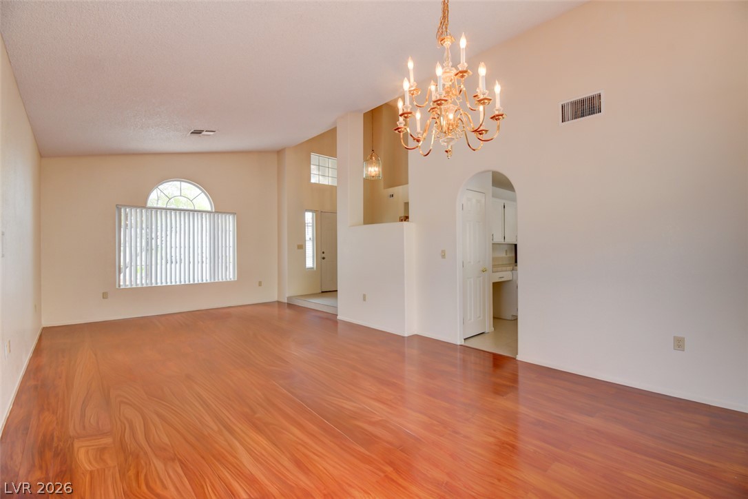 5 Tarryall Terrace Henderson, NV 89074 - Photo 5 of 44 A graceful chandelier illuminates the rich hardwood flooring in this spacious living area.