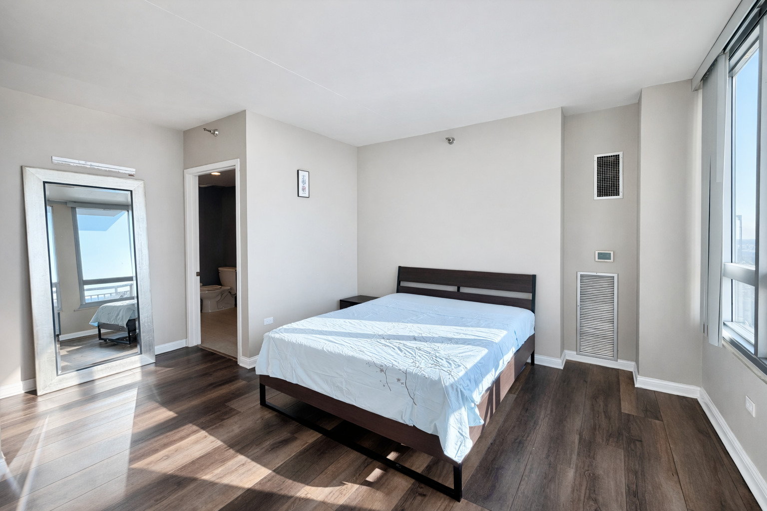 701 South Wells Street, Unit 1506 Chicago, IL 60607 - Photo 11 of 21 a bedroom with a bed and wooden floor