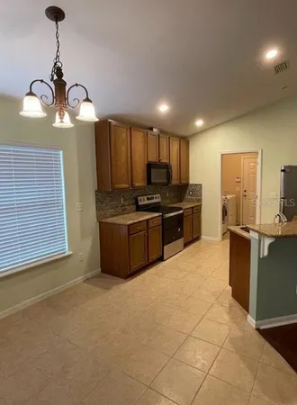 a kitchen with kitchen island granite countertop stainless steel appliances cabinets a sink and a counter top