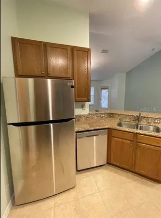 a metallic refrigerator freezer sitting inside of a kitchen