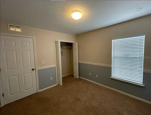 an empty room with windows and cabinet