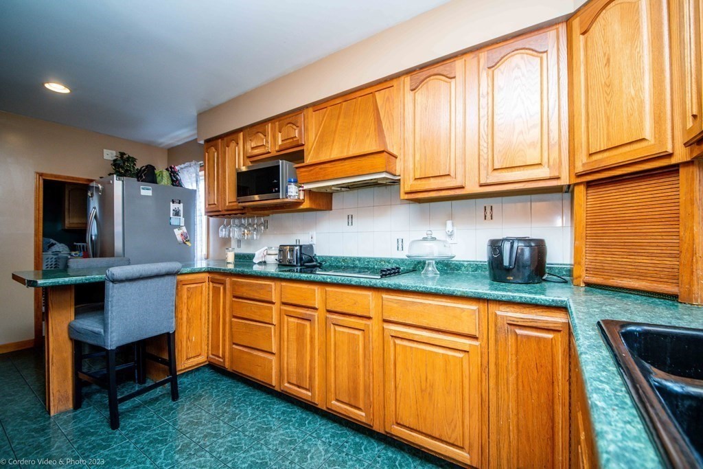 478 Third Street Fall River, MA 02721 - Photo 11 of 35 a kitchen with granite countertop wooden cabinets stainless steel appliances and a sink