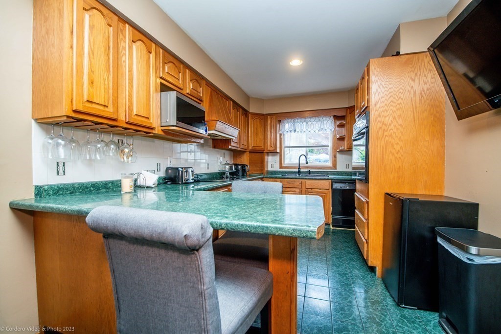 478 Third Street Fall River, MA 02721 - Photo 12 of 35 a kitchen with stainless steel appliances granite countertop a stove a sink and a microwave