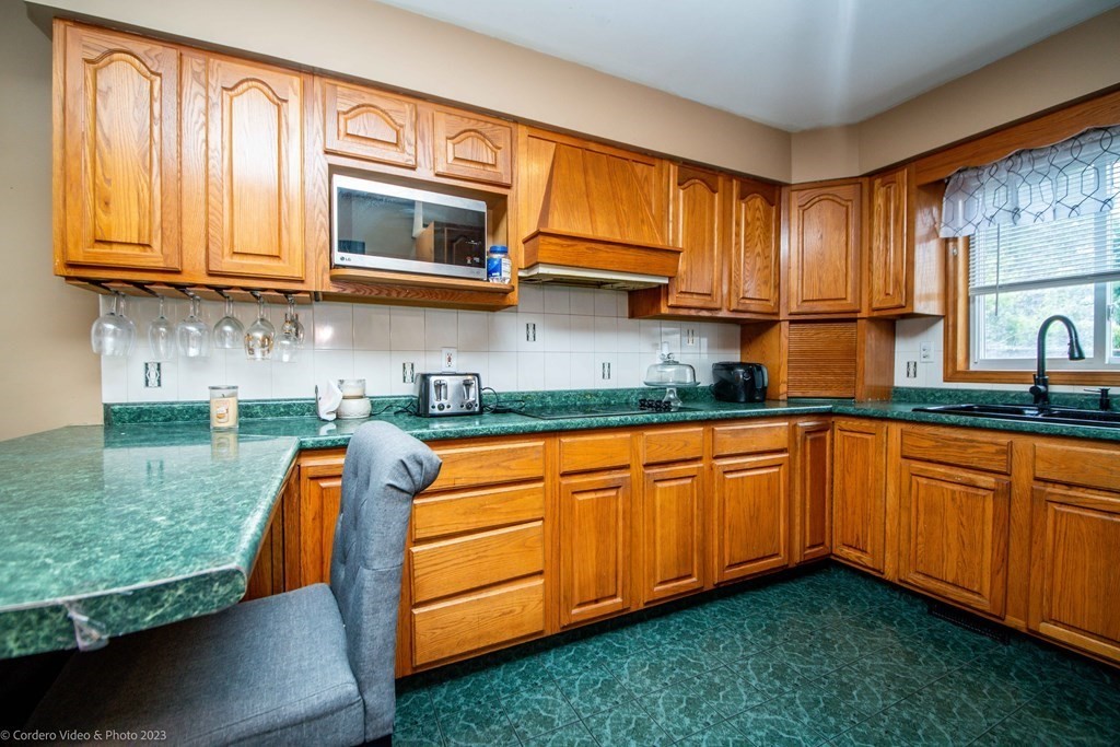 478 Third Street Fall River, MA 02721 - Photo 8 of 35 a kitchen with stainless steel appliances granite countertop wooden cabinets a stove a sink and a window