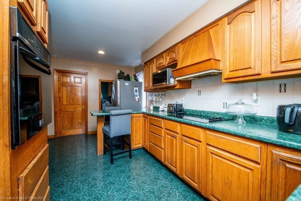 478 Third Street Fall River, MA 02721 - Photo 9 of 35 a kitchen with granite countertop wooden cabinets a sink and dishwasher a stove with wooden floor