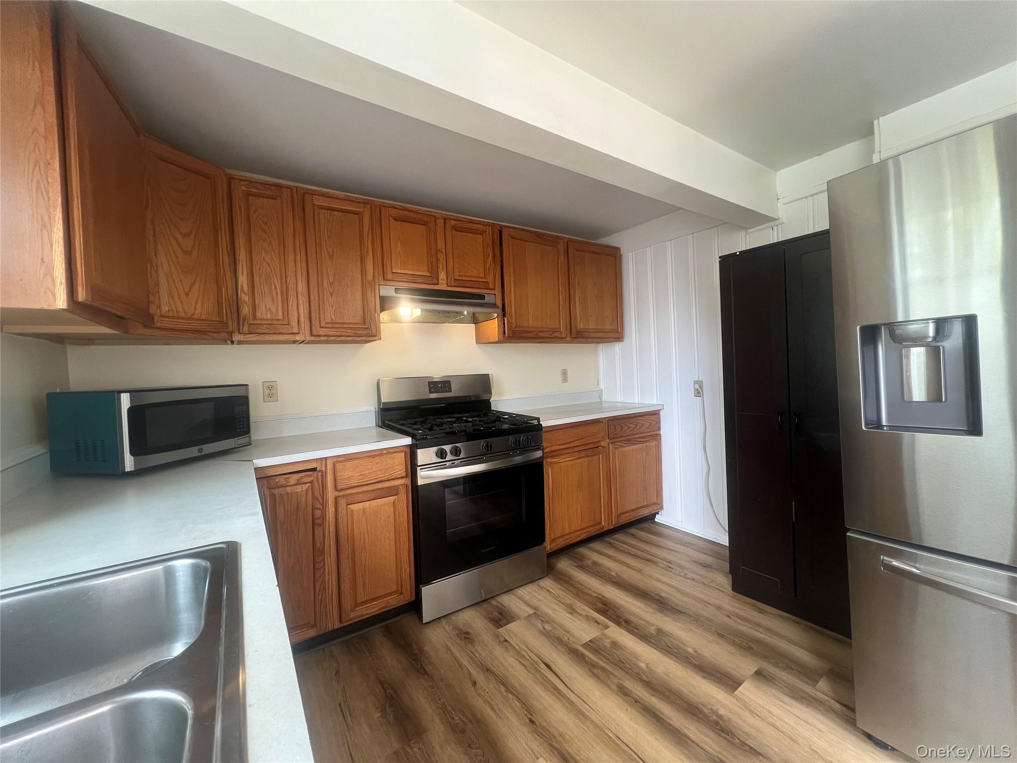 34 Smith Street Poughkeepsie, NY 12601 - Photo 16 of 46 a kitchen with granite countertop stainless steel appliances and wooden cabinets