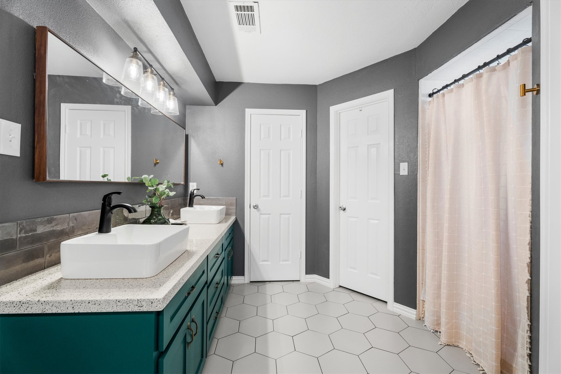 4026 Oxhill Road Spring, TX 77388 - Photo 25 of 40 Designed with both style and function in mind, the spacious primary ensuite features a dual-sink vanity with modern vessel sinks, updated fixtures, expansive counter space, two walk-in closets, and a walk-in shower. Rich paint tones, designer lighting, and elegant finishes create a relaxing retreat.