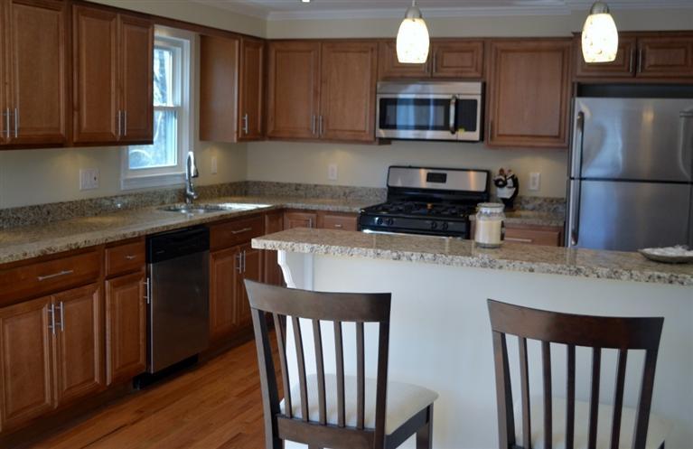 147 Straightway Hyannis, MA 02601 - Photo 8 of 31 a kitchen with stainless steel appliances granite countertop a stove a sink dishwasher and a microwave oven with wooden floor