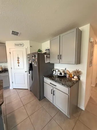 a kitchen with stainless steel appliances granite countertop a stove a refrigerator and a cabinets