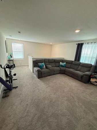 a living room with furniture and a gym machine