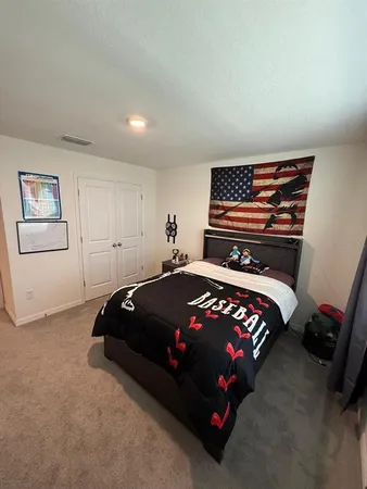 a bedroom with a bed and a painting on the wall