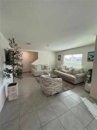 a living room with furniture and a potted plant