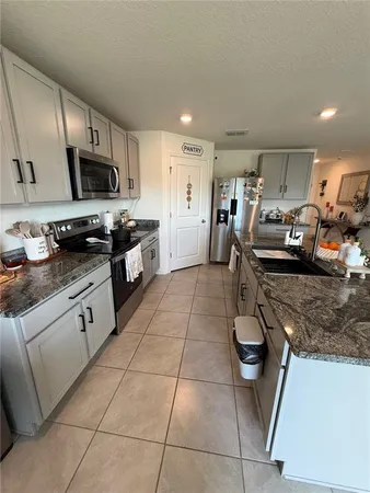 a kitchen with stainless steel appliances granite countertop a sink a stove and cabinets