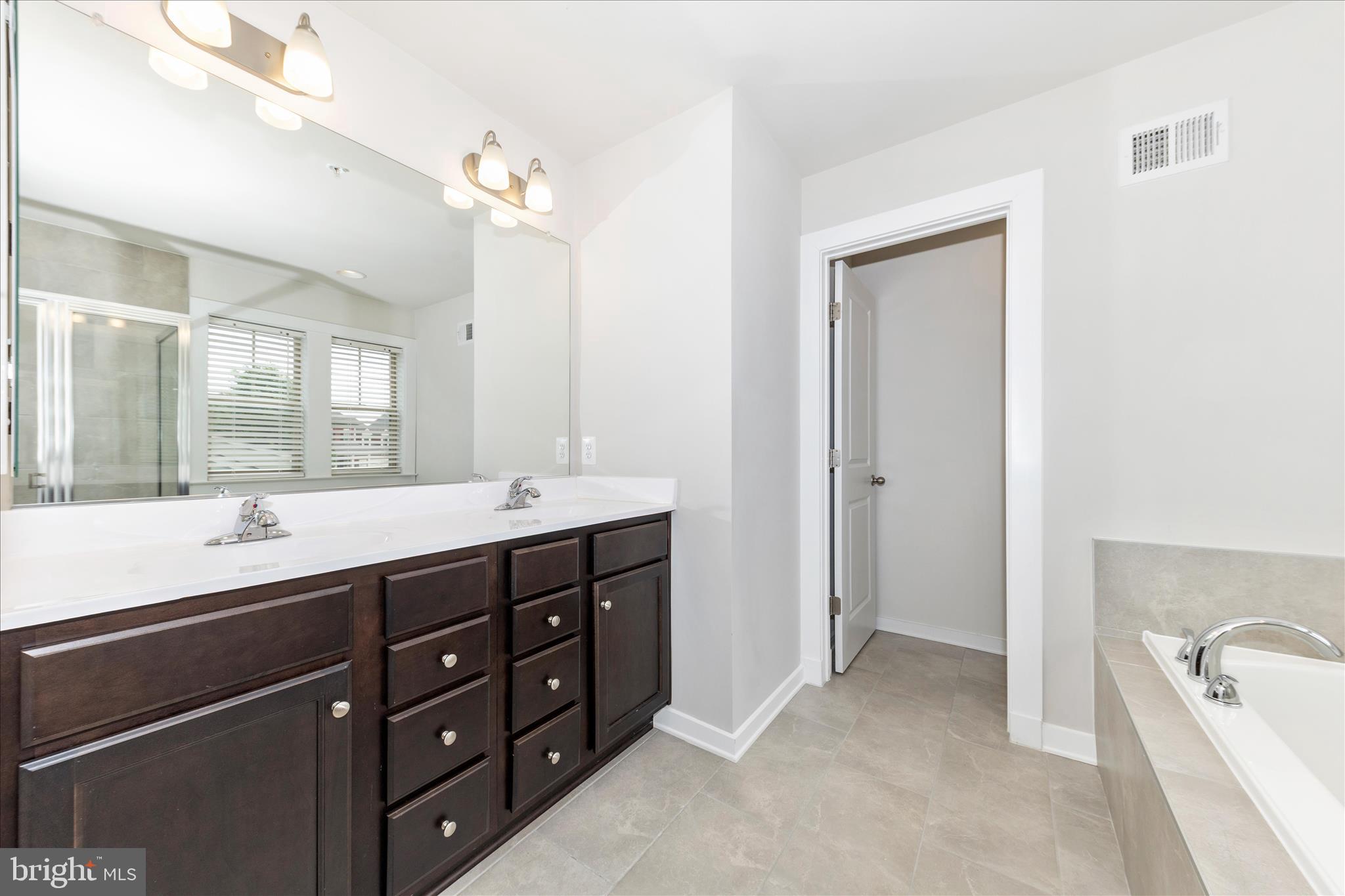 2003 Foster Way Frederick, MD 21702 - Photo 37 of 74 a spacious bathroom with a double vanity sink a large mirror and a bathtub